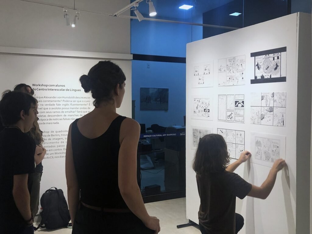 Personas observando y escribiendo sobre paneles en una sala de exposición