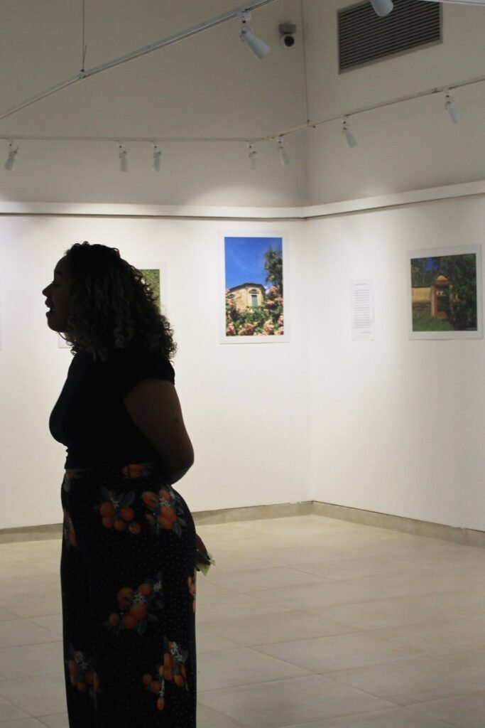 Visitante en silueta recorriendo una exposición de fotografía en una galería