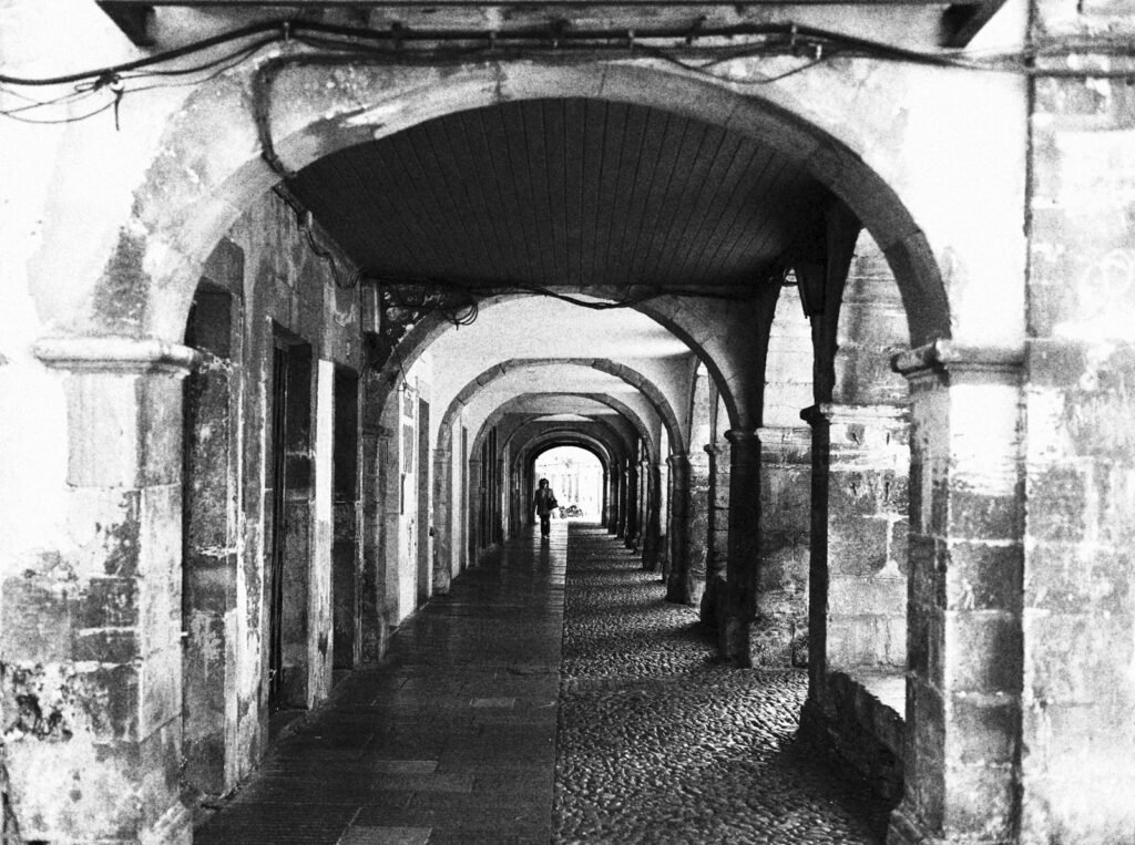 Soportales con arcos de piedra en perspectiva, en blanco y negro
