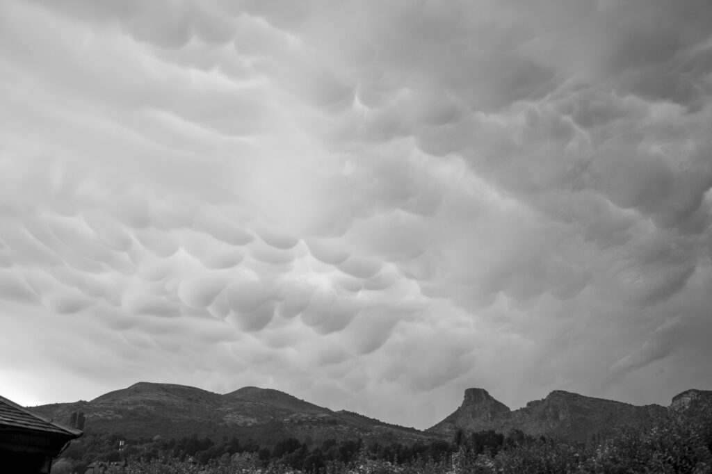 Cielo cubierto de nubes mammatus sobre una sierra, en blanco y negro